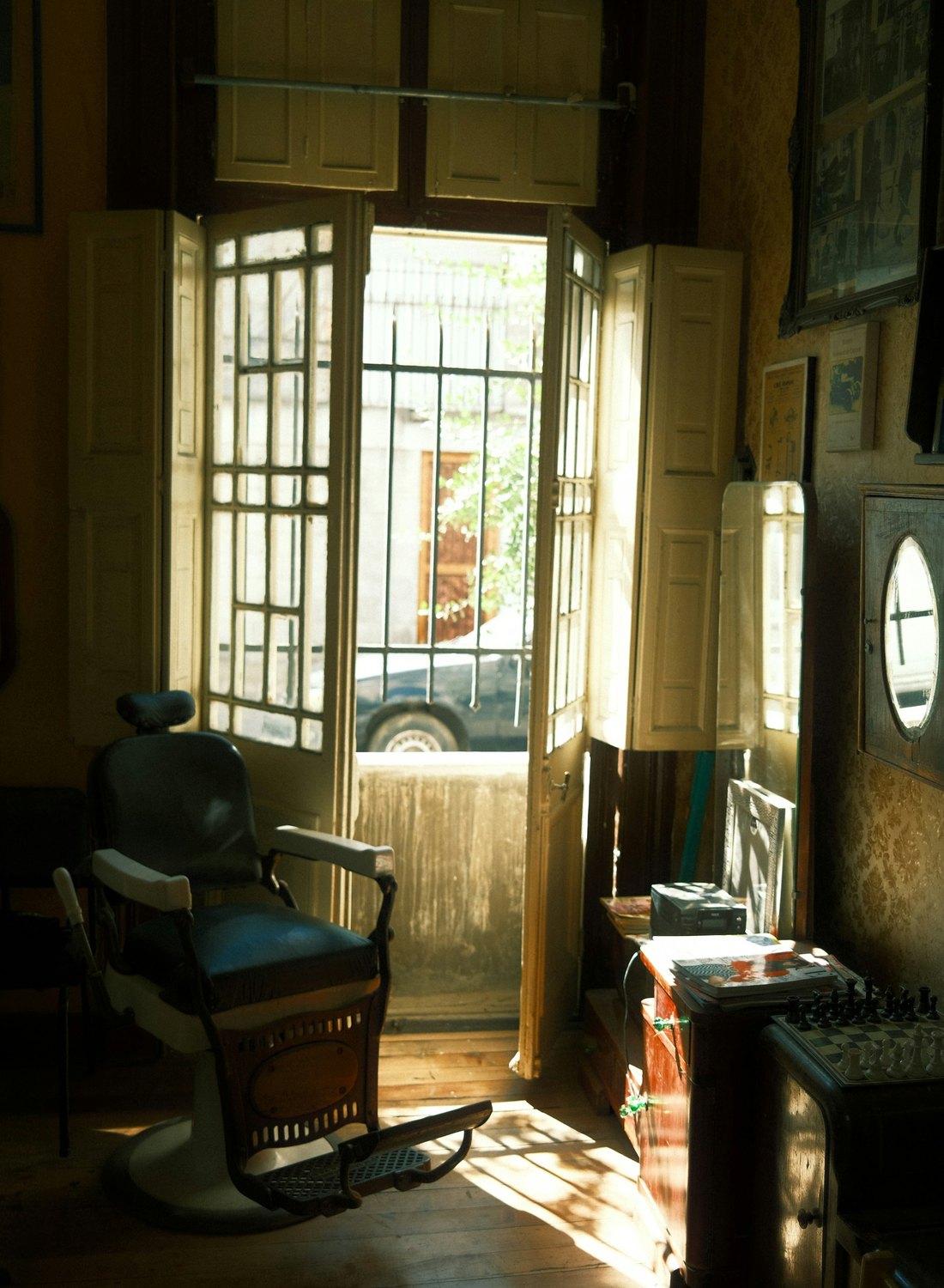 The shop door propped open onto the street, sunlight across the floor